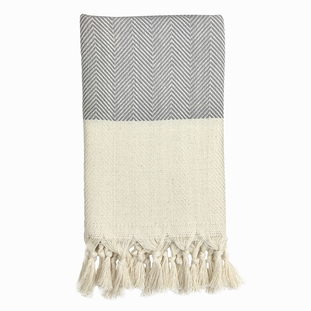Product: The Herringbone Turkish Hand Towel is crafted from 100% Turkish cotton and displays a blue and white herringbone design, accented with a cream fringe border.