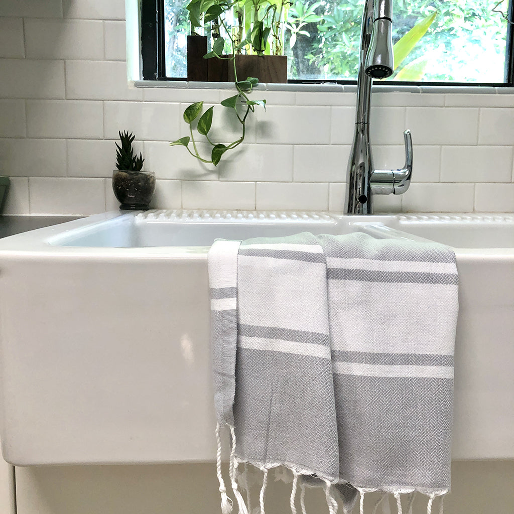 Introducing the Essential Stripe Turkish Hand Towel: crafted from 100% Turkish cotton, this towel combines gray and white stripes with fringed edges and exceptional absorbency.