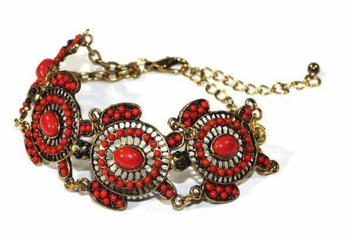 The Colorful Bead Drop Turtle Bracelet is a handmade piece featuring red and orange stones in circular patterns on a gold chain with clasp, boasting an antique style finish that adds timeless elegance to any collection.