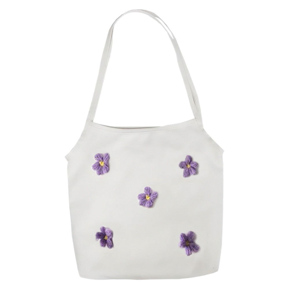 The Lily Canvas Shopper Tote is an eco-friendly cotton canvas bag featuring exquisite purple flower embroidery on the front.