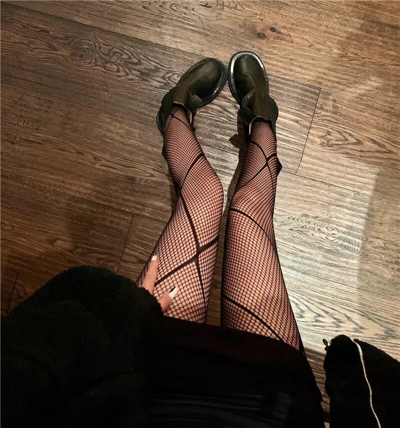 A rebellious woman wearing Edgy Elegance fishnet stockings and black boots.