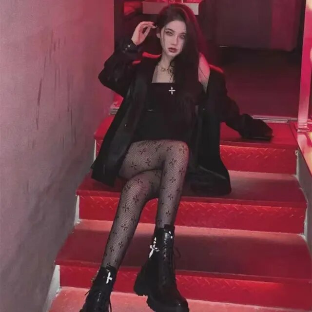 A rebellious woman wearing Edgy Elegance fishnet stockings and black boots.