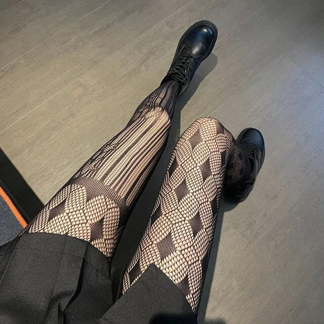 A rebellious woman wearing Edgy Elegance fishnet stockings and black boots.