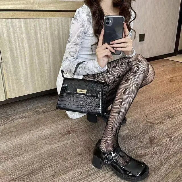 A rebellious woman wearing Edgy Elegance fishnet stockings and black boots.