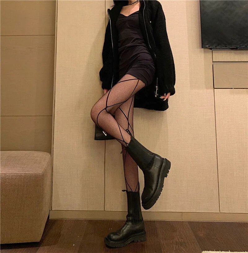 A rebellious woman wearing Edgy Elegance fishnet stockings and black boots.