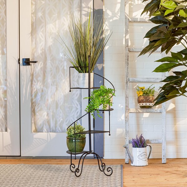 A Summerfield Terrace Iron Spiral Staircase Plant Stand with two shelves.