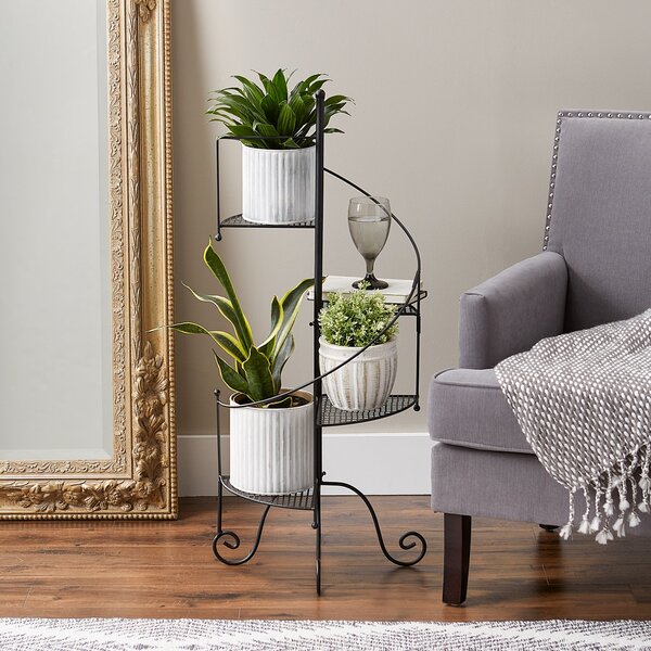 A Summerfield Terrace Iron Spiral Staircase Plant Stand with two shelves.