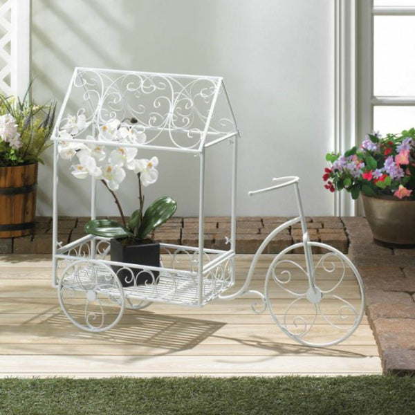 A Summerfield Terrace White Iron Tricycle Plant Cart with a white house on it.