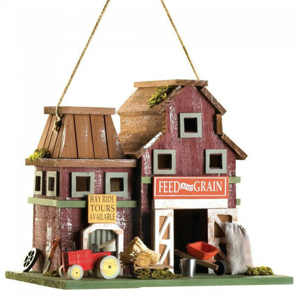 A Songbird Valley Feed and Grain Farmhouse Bird House with a red barn and a tractor.