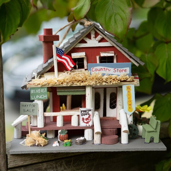 A Songbird Valley Wood Country Store Bird House with an american flag on it.