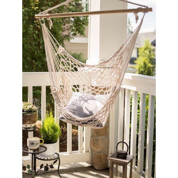 A Summerfield Terrace Recycled Cotton Swinging Hammock Chair hanging on a wooden frame.