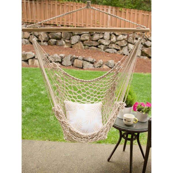 A Summerfield Terrace Recycled Cotton Swinging Hammock Chair hanging on a wooden frame.