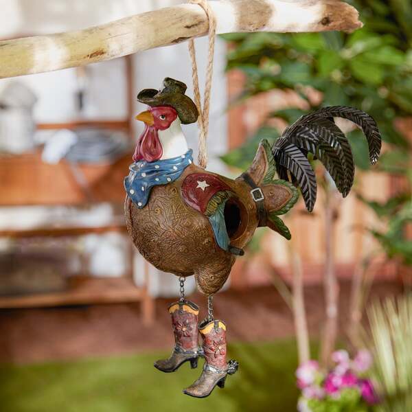 A Songbird Valley Rooster Cowboy Bird House hanging from a string.