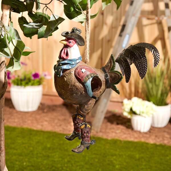 A Songbird Valley Rooster Cowboy Bird House hanging from a string.