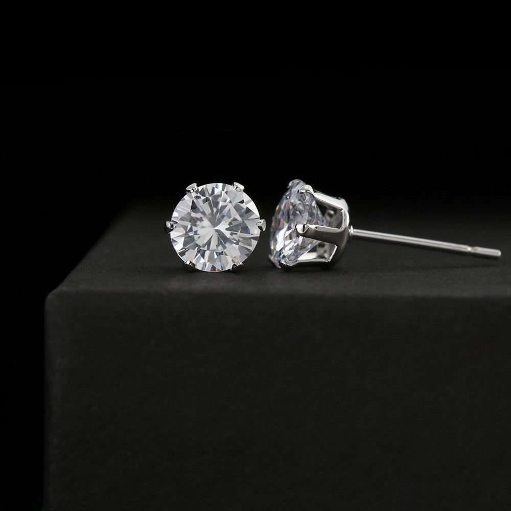 A pair of Cubic Zirconia Earrings displayed on a black velvet stand against a dark background.