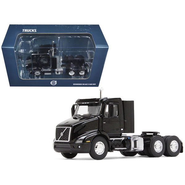 A Volvo VNR 300 Day Cab Sable Black Metallic 1/50 Diecast Model Car by First Gear truck in a box next to a box.