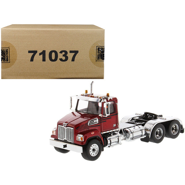 A Western Star 4700 SF Tandem Day Cab Tractor Metallic Red 1/50 Diecast Model by Diecast Masters with a box next to it.