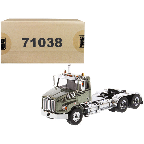 A Western Star 4700 SB Tandem Day Cab Tractor Metallic Olive Green 1/50 Diecast Model by Diecast Masters with a box next to it.