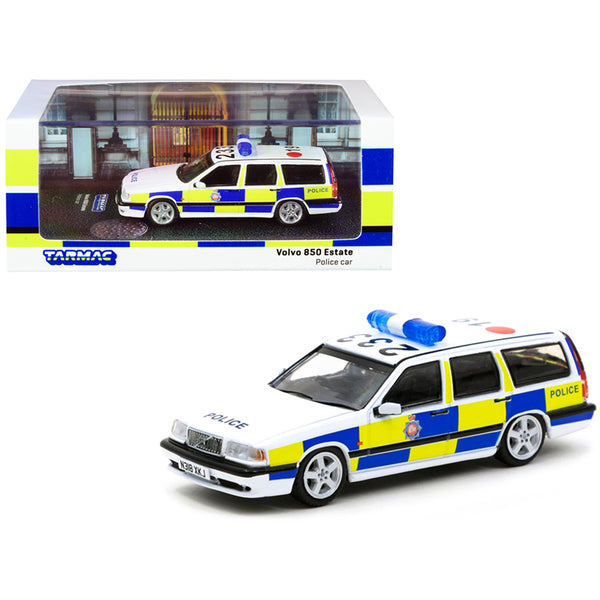 A Volvo 850 Estate RHD (Right Hand Drive) GMP "Greater Manchester Police" (United Kingdom) Police Car 1/64 Diecast Model Car by Tarmac Works in front of a box.