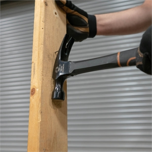 A person using a Southwire BMEH-20 Hammer to hammer a piece of wood.