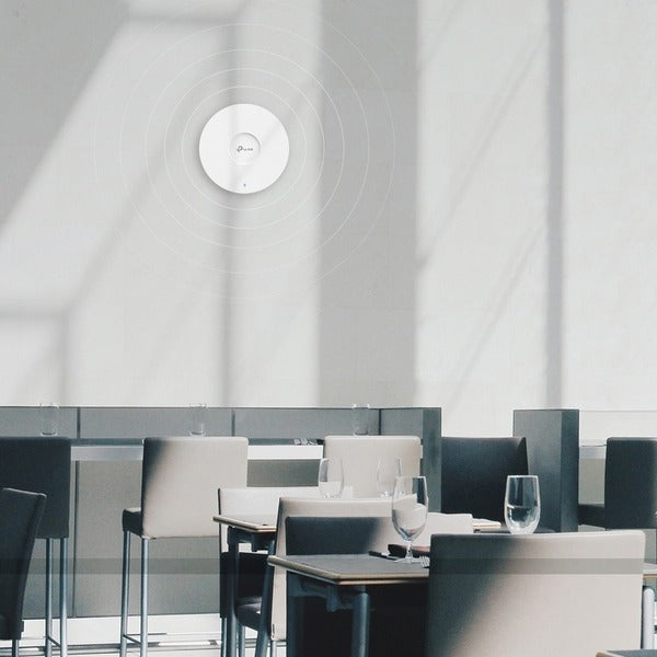 A TP-Link EAP670 Dual Band IEEE 802.11 a/b/g/n/ac/ax 5.27 Gbit/s Wireless Access Point with a blue light on it.