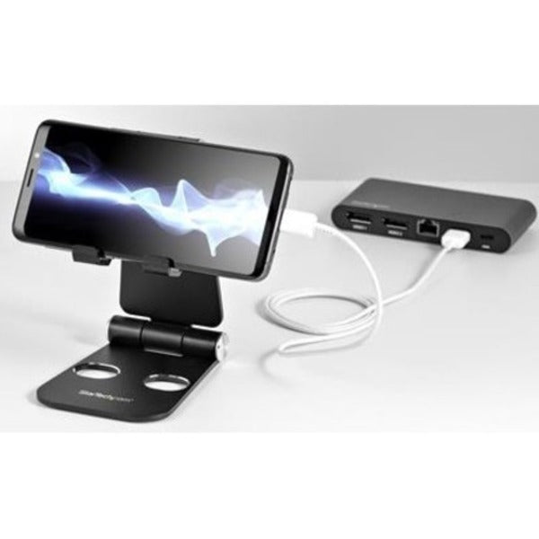 A StarTech.com Phone and Tablet Stand - Foldable Universal Mobile Device Holder - Smartphones/Tablets - Adjustable Cell Phone Stand for Desk with a metal stand.