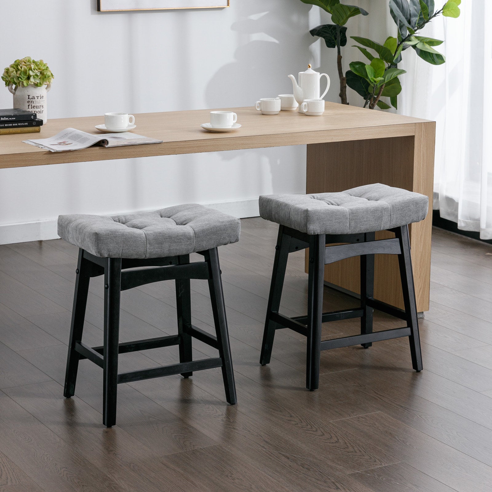 Two A&A Furniture, Counter Height 25" Stools for Kitchen Counter Backless Faux Leather Stools Farmhouse Island Chairs (25 Inch, Gray, Set of 2), SW1838GY in a room with a wooden table.