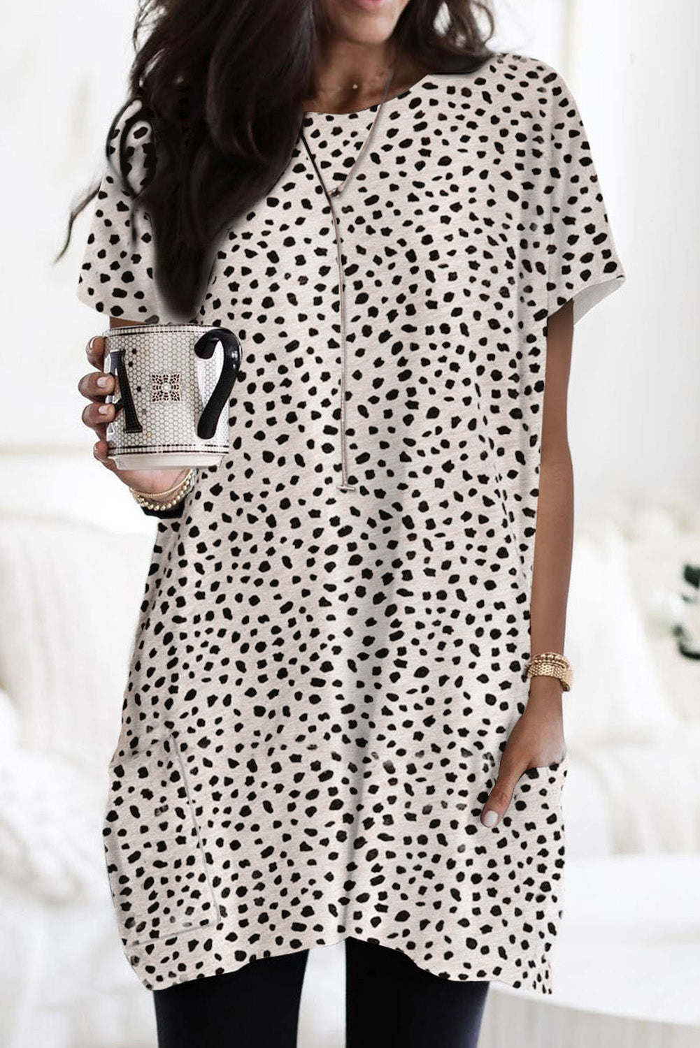 A woman wearing a black leopard print side pockets tunic top.