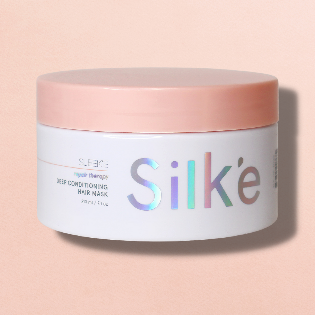 A jar of Silk'e Repair therapy Hair Mask on a pink background.