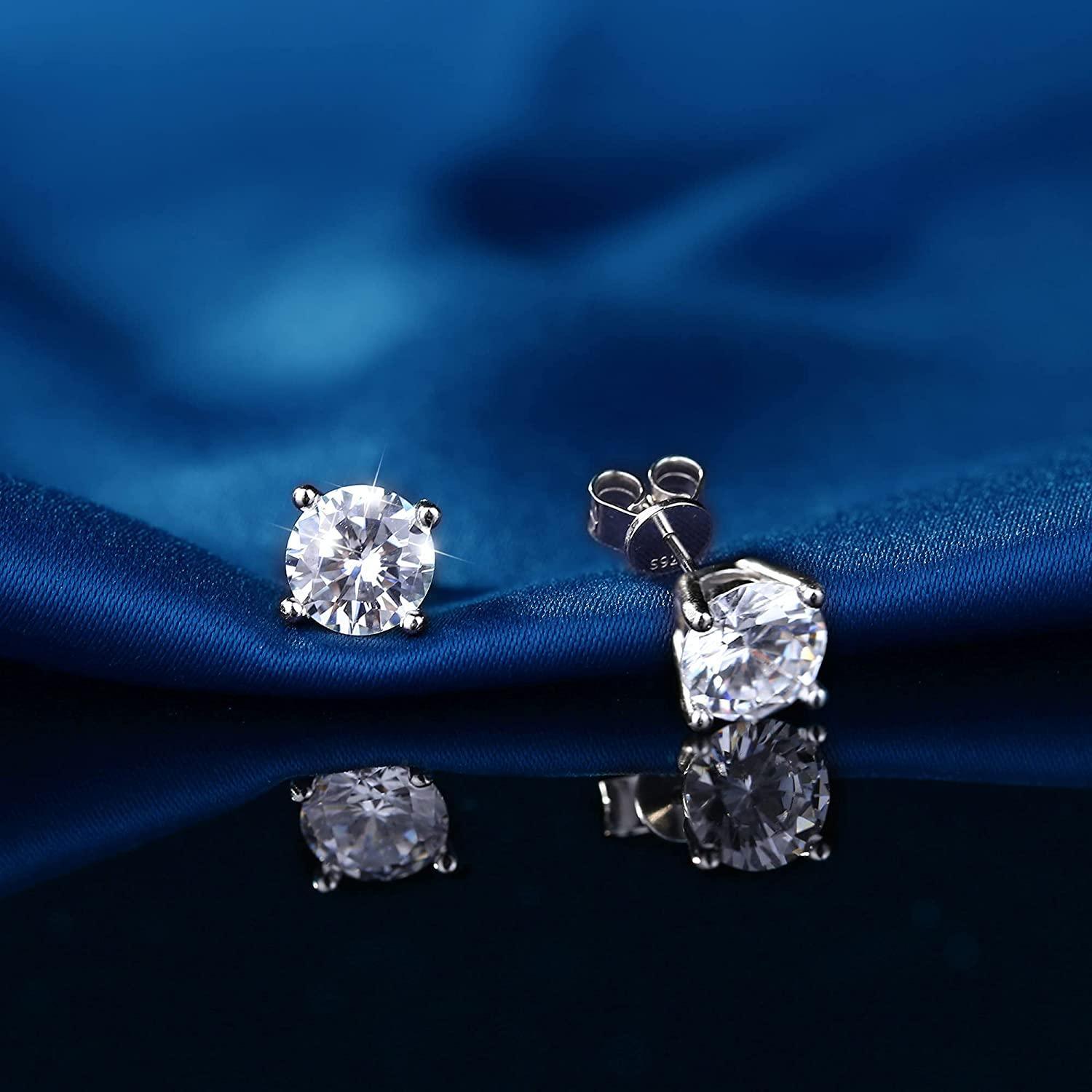 Close-up image of the Sterling Silver Cubic Zirconia Stud Earrings for Women Men, which feature round-cut, sparkling cubic zirconia gemstones set in 14k white gold plated metal with S925 engraved on the post, indicating hypoallergenic sterling silver.