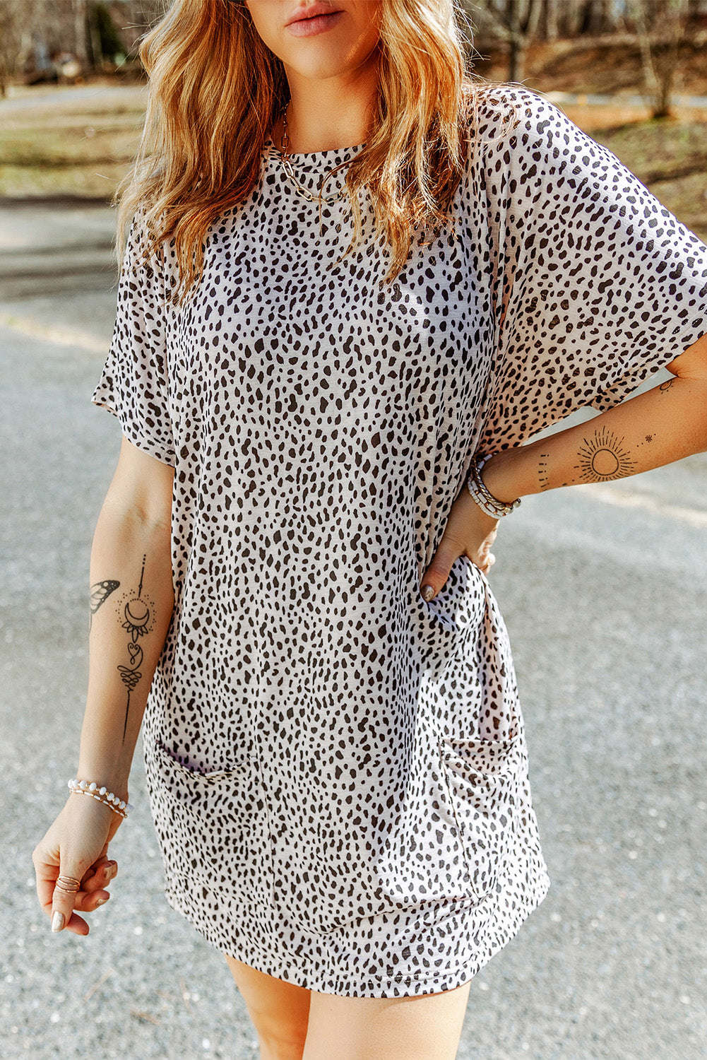 A woman wearing a black leopard print side pockets tunic top.