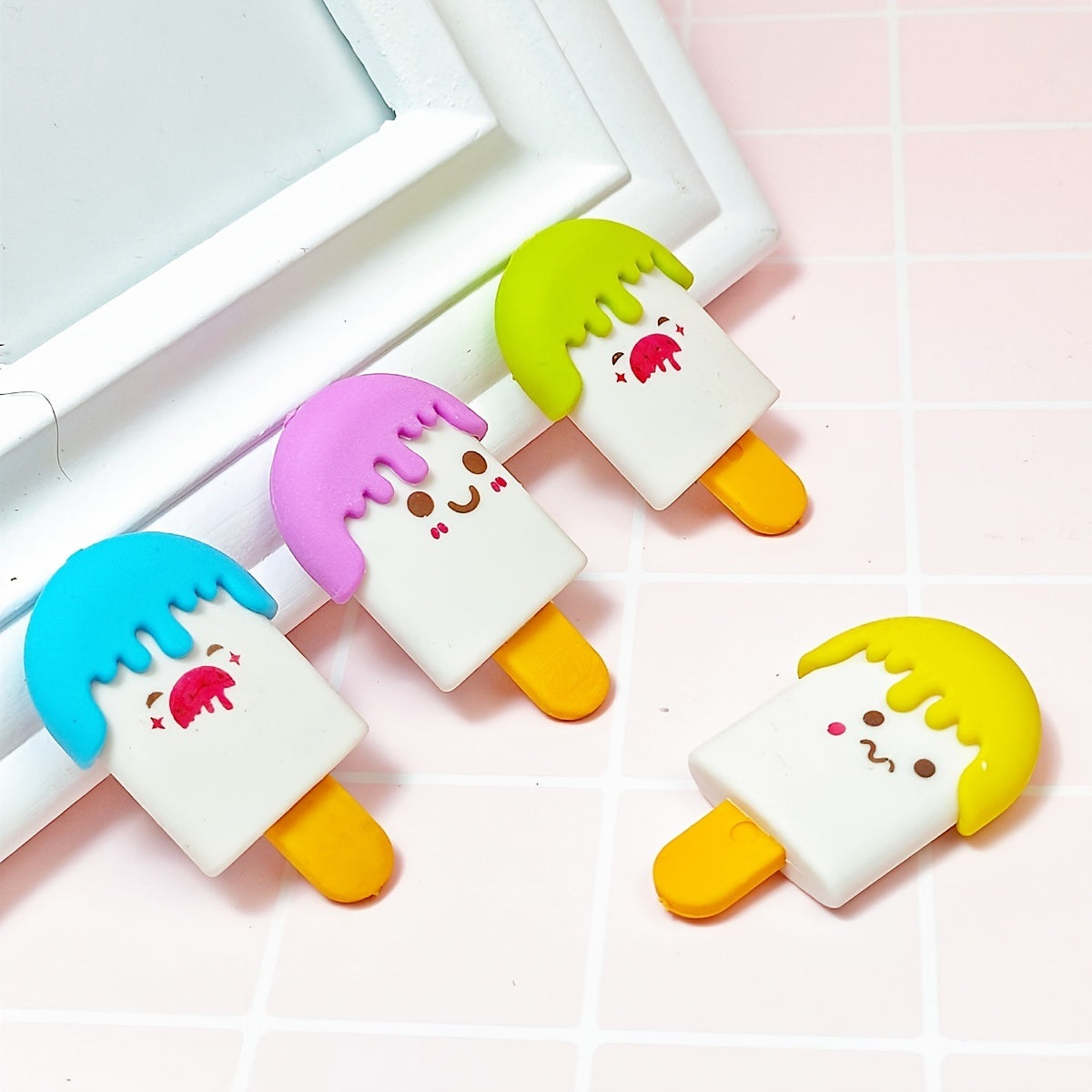 Four colorful 4pcs Ice Cream Shaped Erasers with cartoon faces, displayed on a bench against a backdrop labeled "Chanel.