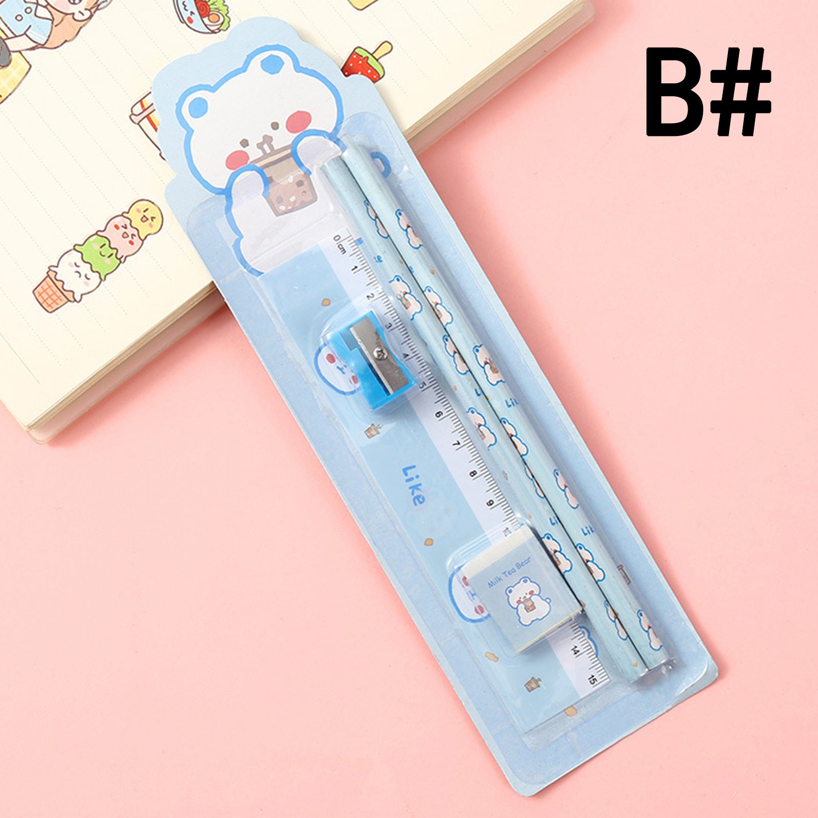 A blue bear-themed plastic ruler with a sliding gauge, designed for a young target audience, placed on an open notebook featuring cartoon drawings.