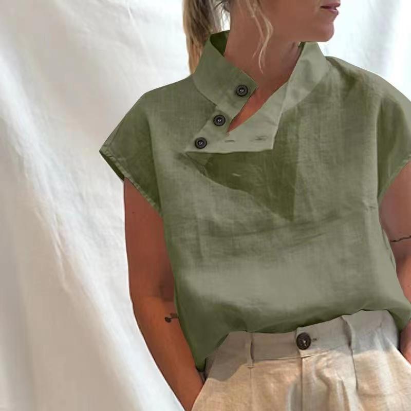 Person wearing a Stylish Blouses Summer Women Cotton Linen Short Sleeve Buttons Solid Shirt in navy blue, paired with light-colored trousers, standing against a plain backdrop.