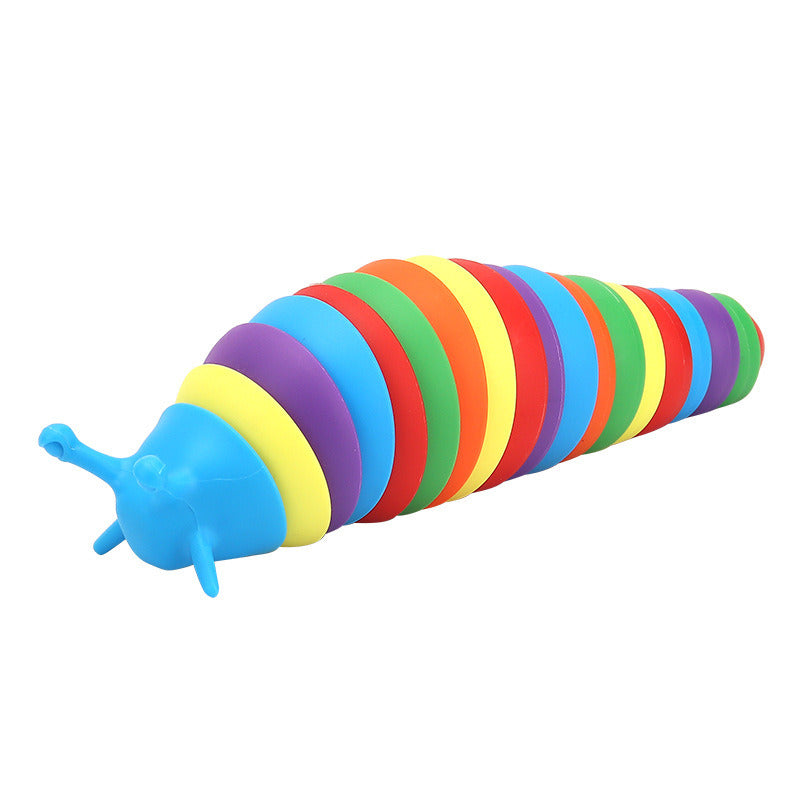 A colorful silicone Fidget Slug toy designed for educational purposes, in a rainbow design, held in a person's hand with packaging visible in the background.