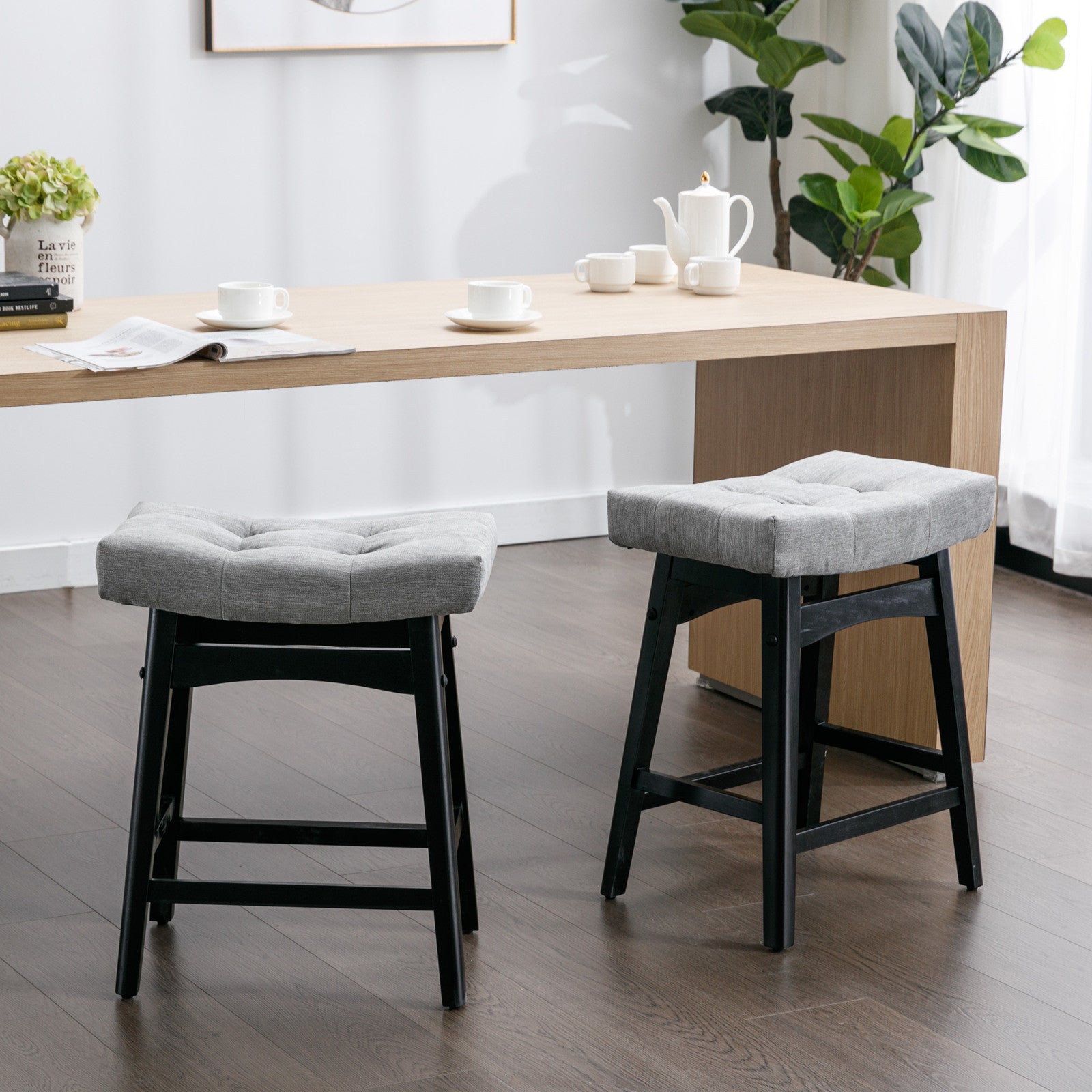Two A&A Furniture, Counter Height 25" Stools for Kitchen Counter Backless Faux Leather Stools Farmhouse Island Chairs (25 Inch, Gray, Set of 2), SW1838GY in a room with a wooden table.