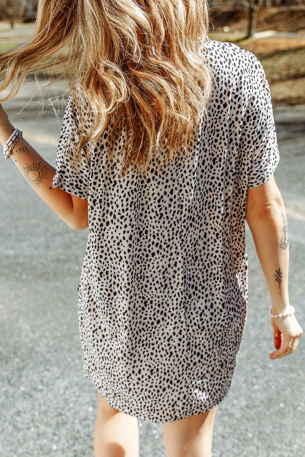 A woman wearing a black leopard print side pockets tunic top.