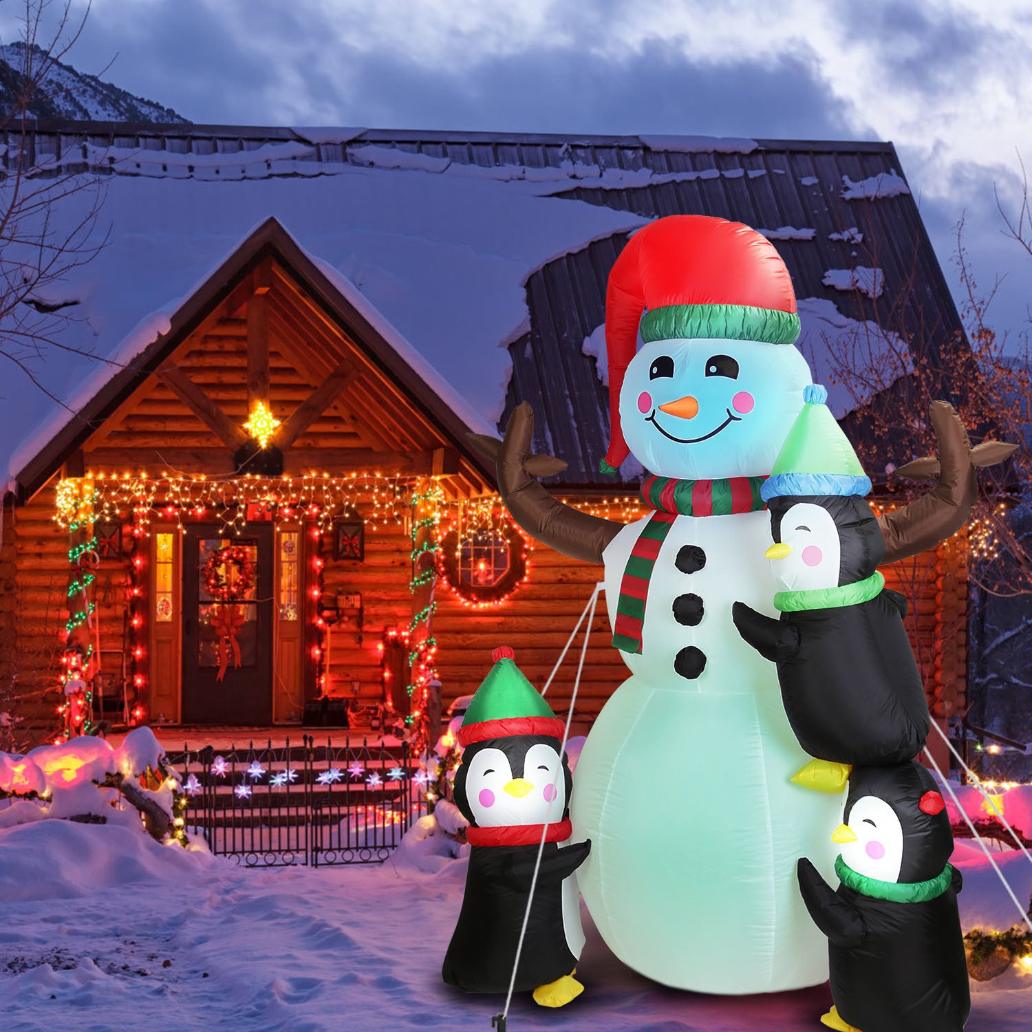 5.9FT Christmas Inflatable Outdoor Decoration Snowman Penguin Blow Up Yard Decoration with LED Light Built-in Air Blower for Winter Holiday Xmas Garden and snow-covered mountains in the background at dusk.