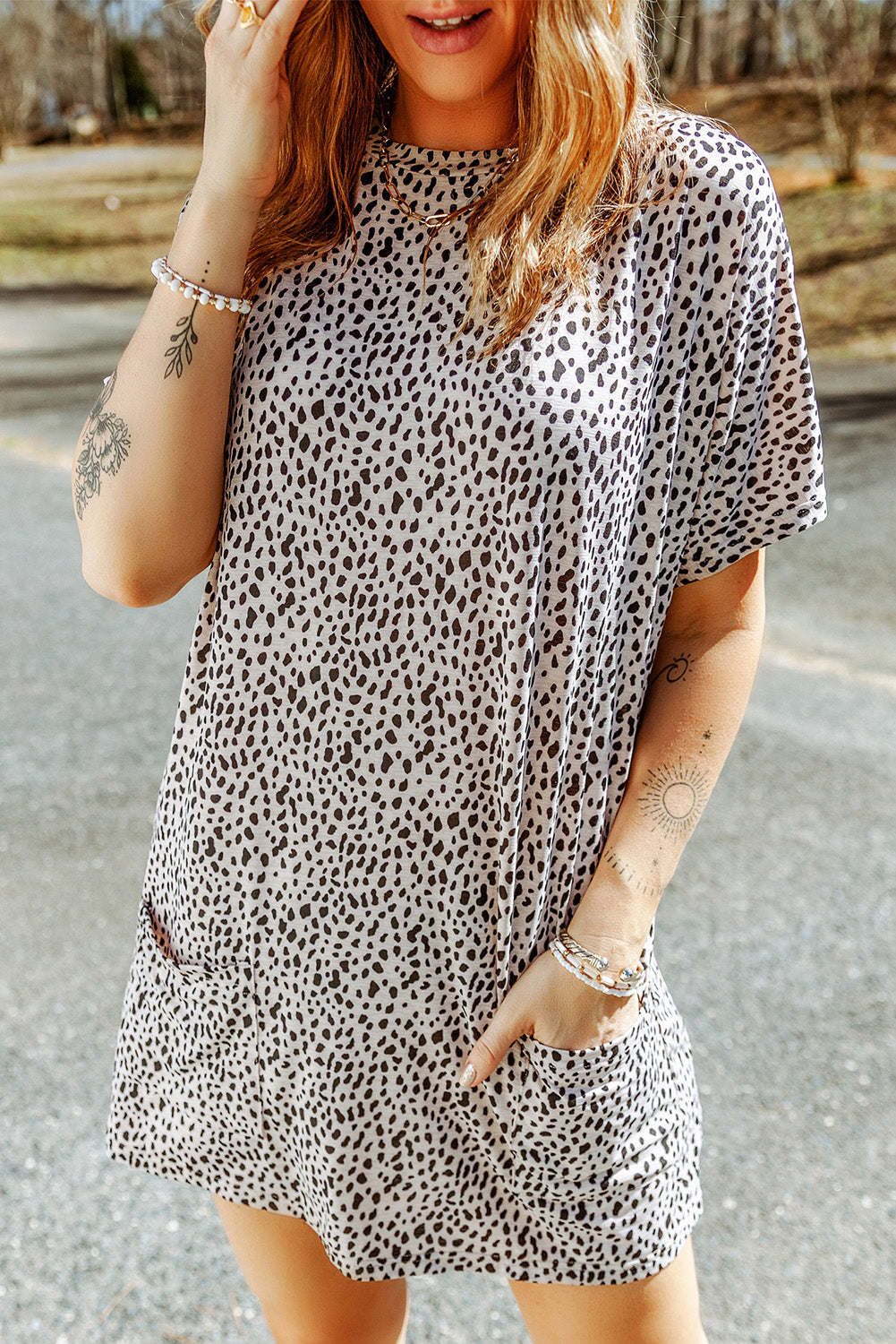 A woman wearing a black leopard print side pockets tunic top.