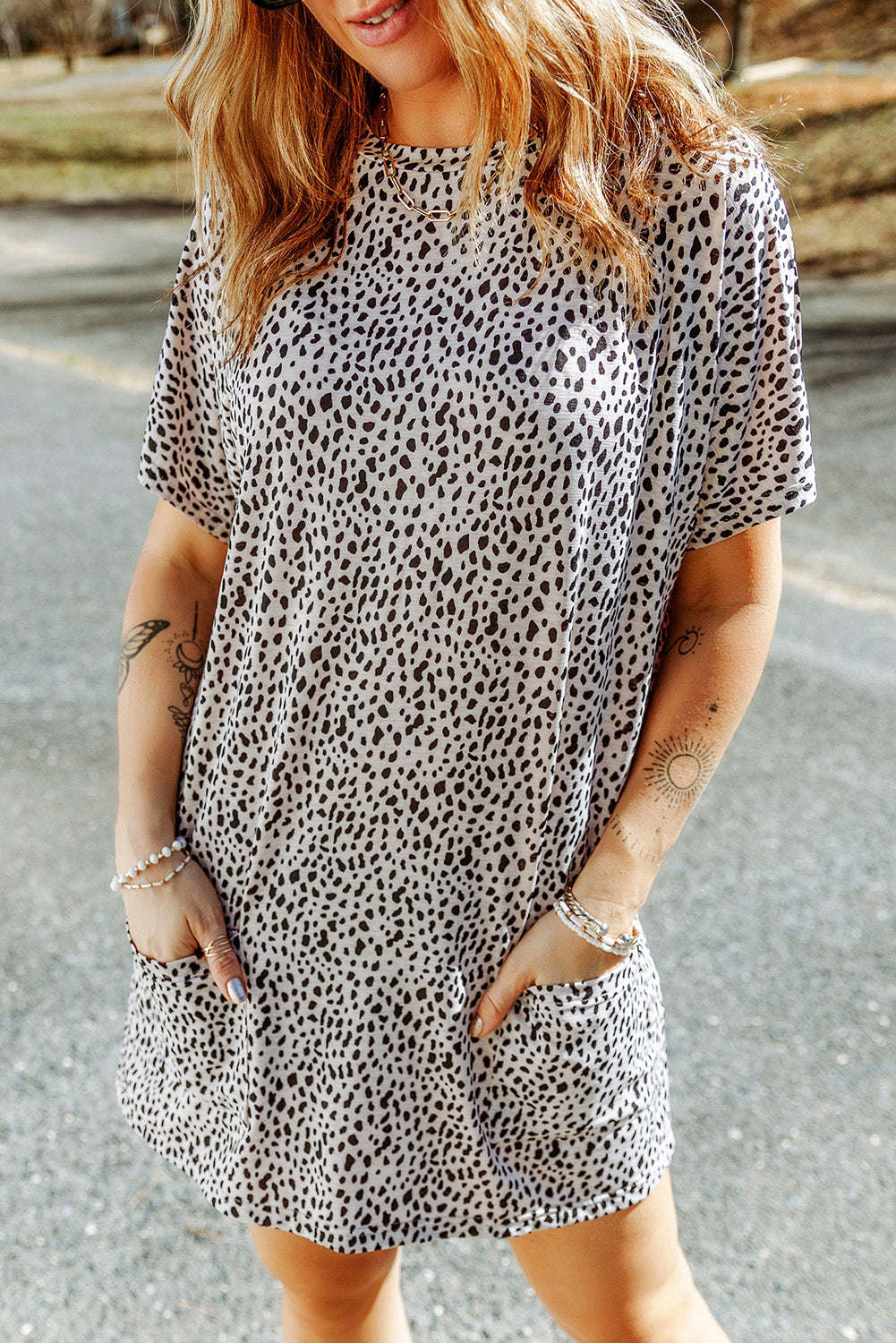 A woman wearing a black leopard print side pockets tunic top.