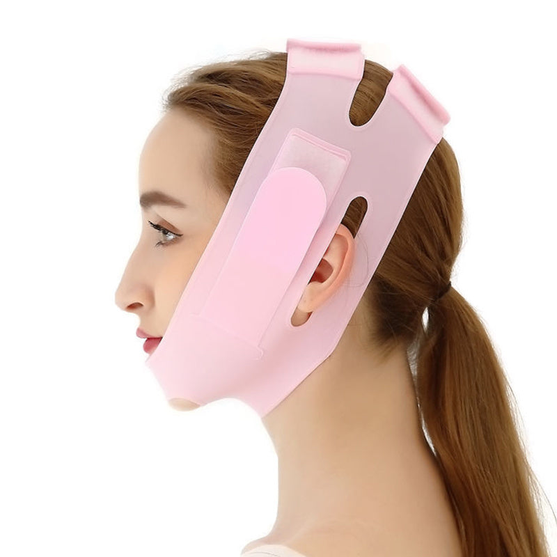 A person wearing a Women Chin Cheek Silicone Face Slimming Bandage Lift Up Belt V Line Face Shaper Facial Anti Wrinkle Strap Skin Care Beauty Tools that covers the chin and wraps around the back of the head. Their hand gently touches the bandage, highlighting its intricate details.