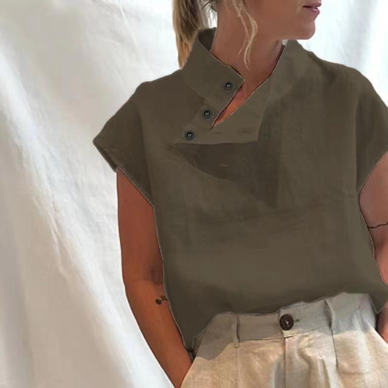 Person wearing a Stylish Blouses Summer Women Cotton Linen Short Sleeve Buttons Solid Shirt in navy blue, paired with light-colored trousers, standing against a plain backdrop.