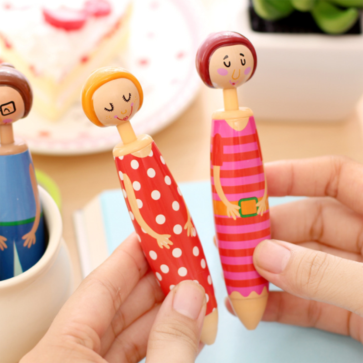 The Pottery Doll Pens Set includes five high-quality ballpoint gel pens, each featuring a wooden top designed as people with different outfits and expressions. This set makes a perfect novelty gift for anyone who loves unique stationery.