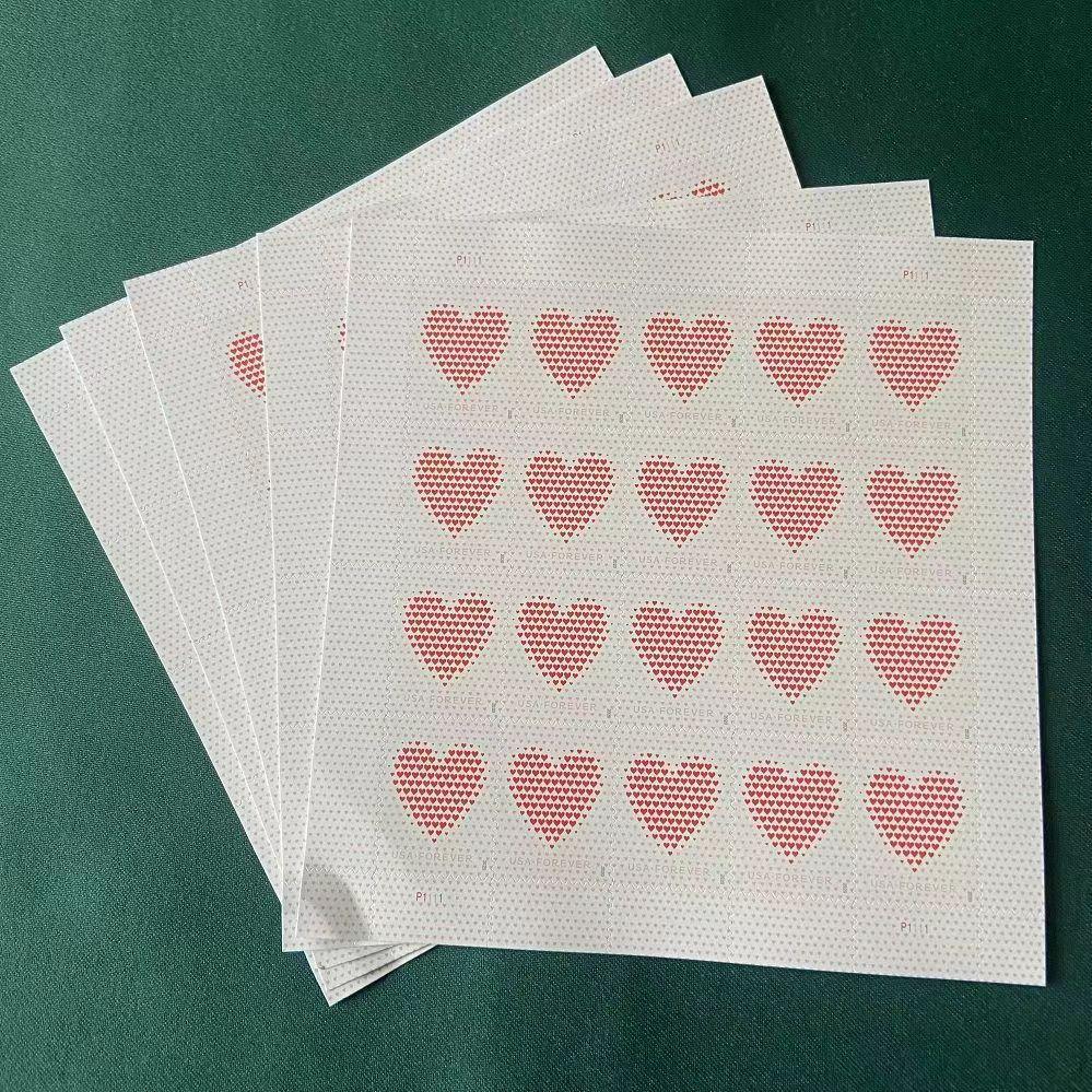 A hand of Made of Hearts 2020 - 5 Sheets / 100 Pcs fanned out on a green surface, each showing a suit of hearts visible from the corner, with details made of hearts.