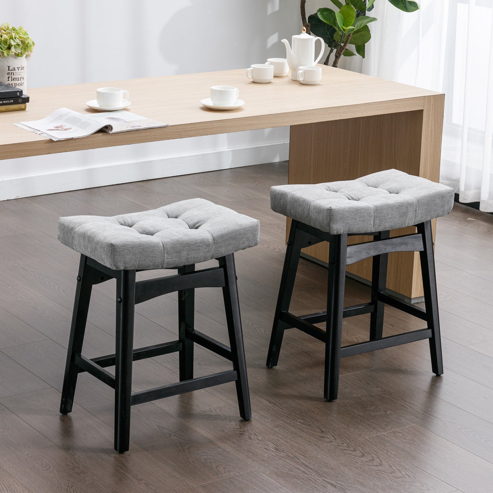 Two A&A Furniture, Counter Height 25" Stools for Kitchen Counter Backless Faux Leather Stools Farmhouse Island Chairs (25 Inch, Gray, Set of 2), SW1838GY in a room with a wooden table.