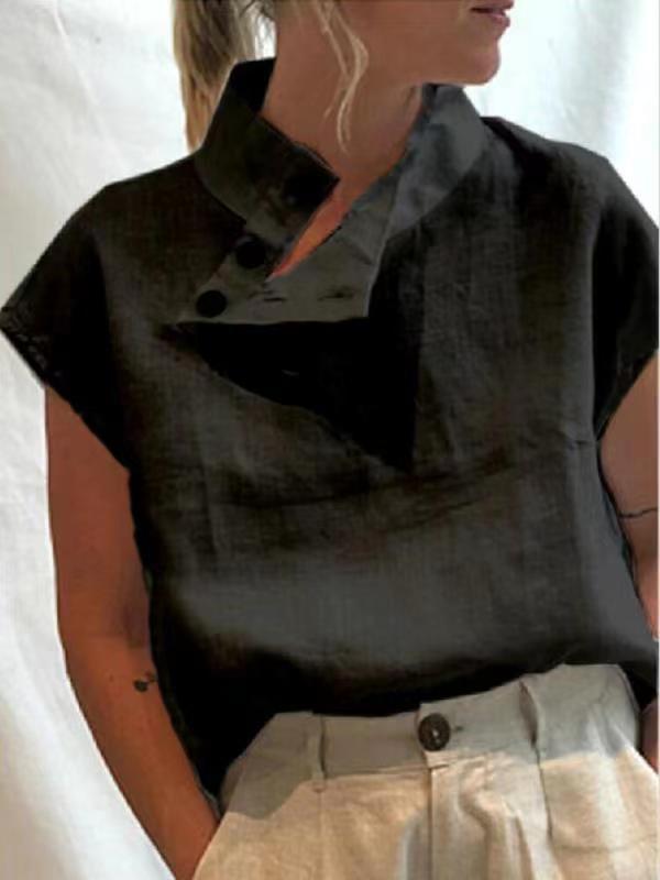 Person wearing a Stylish Blouses Summer Women Cotton Linen Short Sleeve Buttons Solid Shirt in navy blue, paired with light-colored trousers, standing against a plain backdrop.