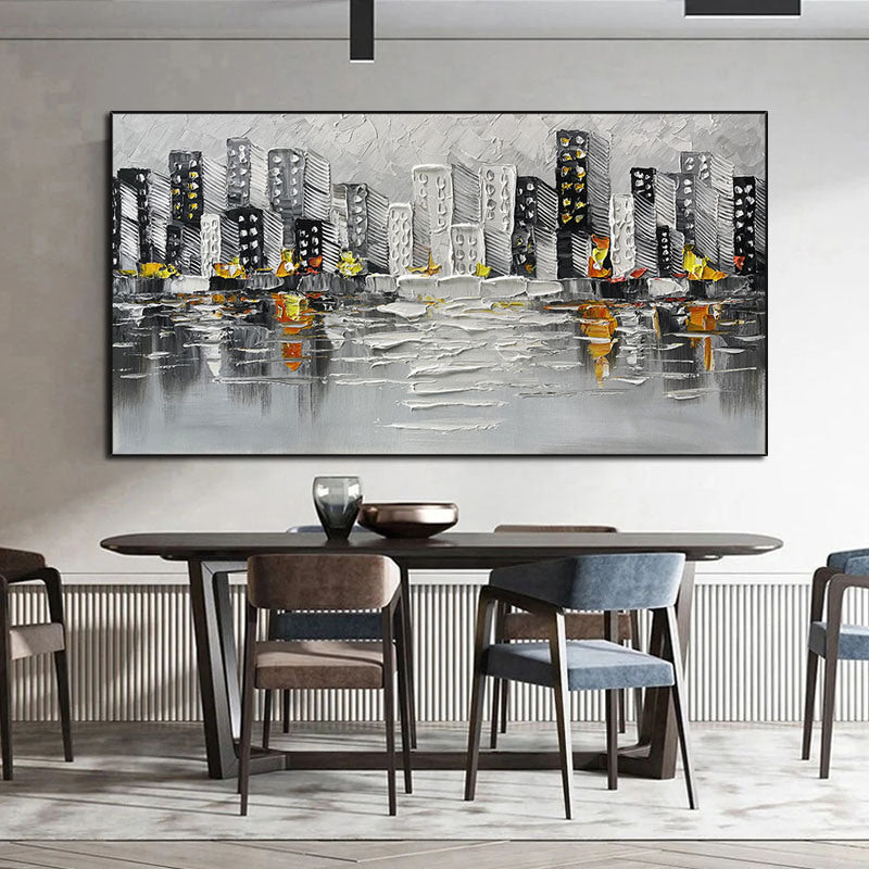 Sentence with the product name: Abstract Art White Pictures Canvas Painting of a cityscape above a green sofa, featuring gray and black buildings with yellow and orange accents, reflected on a water-like surface.