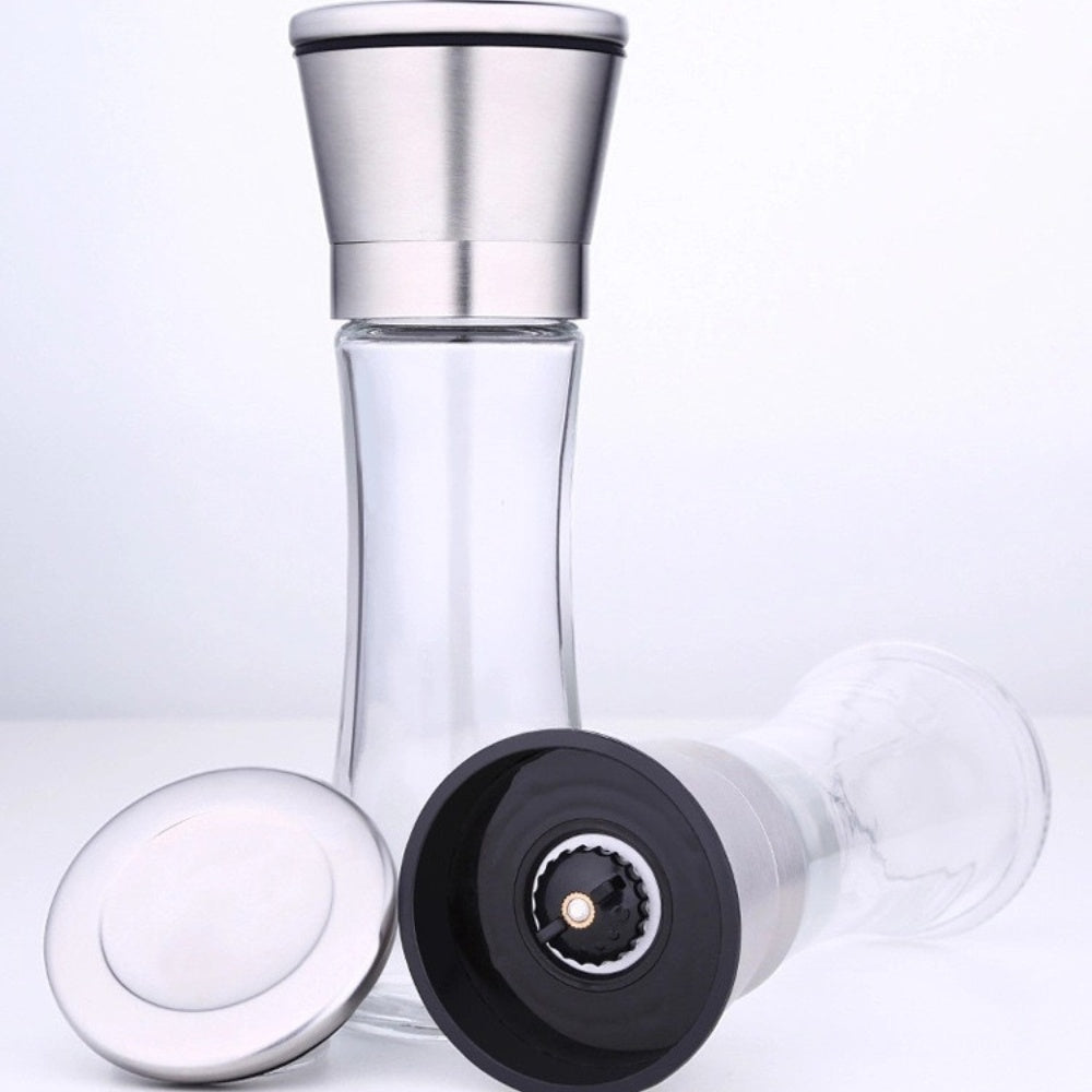 Two large capacity manual pepper mills with adjustable grind settings in a stainless steel holder, filled with pink Himalayan salt and mixed peppercorns.