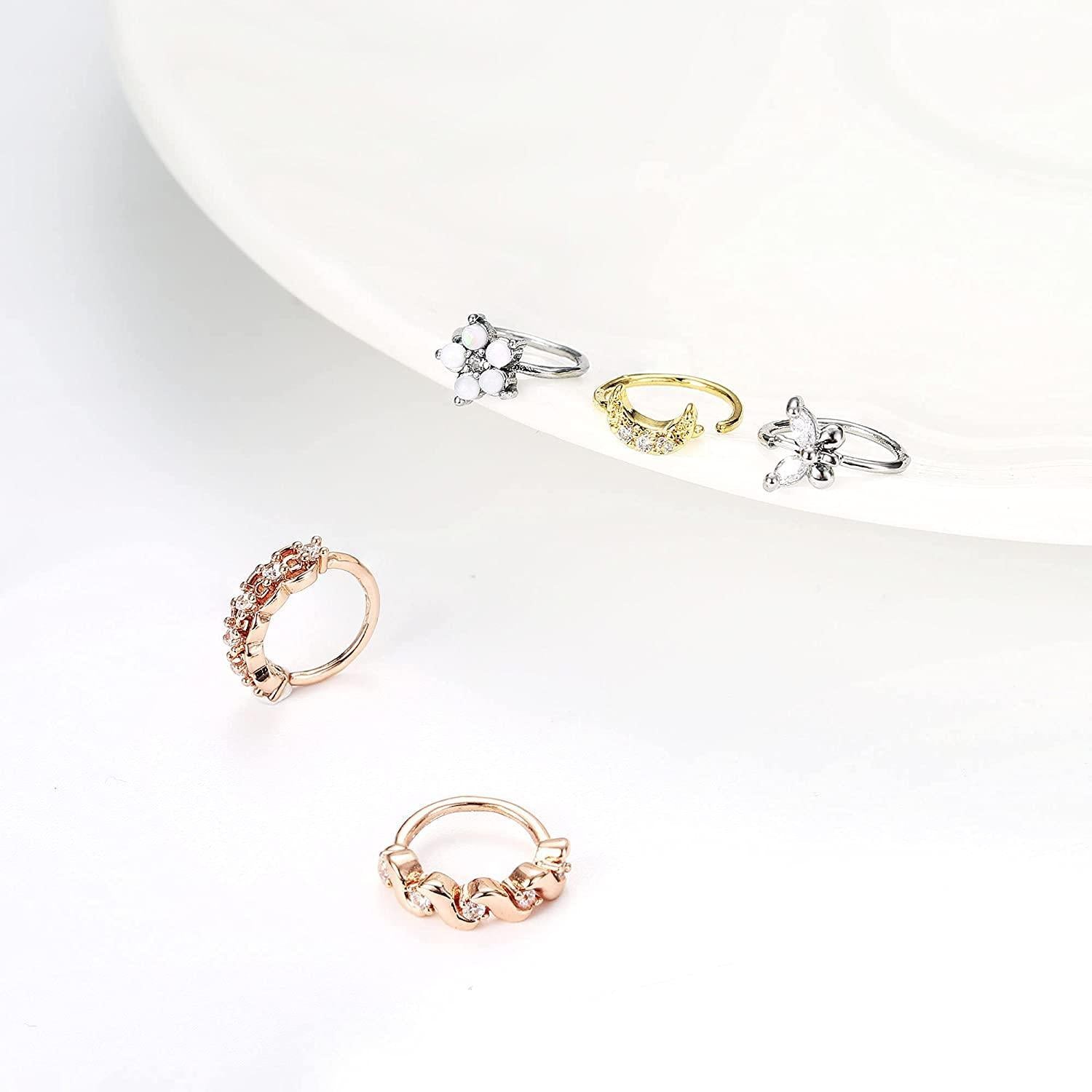 A variety of 9Pcs 20G Stainless Steel Nose Ring Hoop for Women Men in silver, gold, and rose gold tones, each decorated with different elements like pearls, crystals, floral motifs, and cartilage hoop rings.