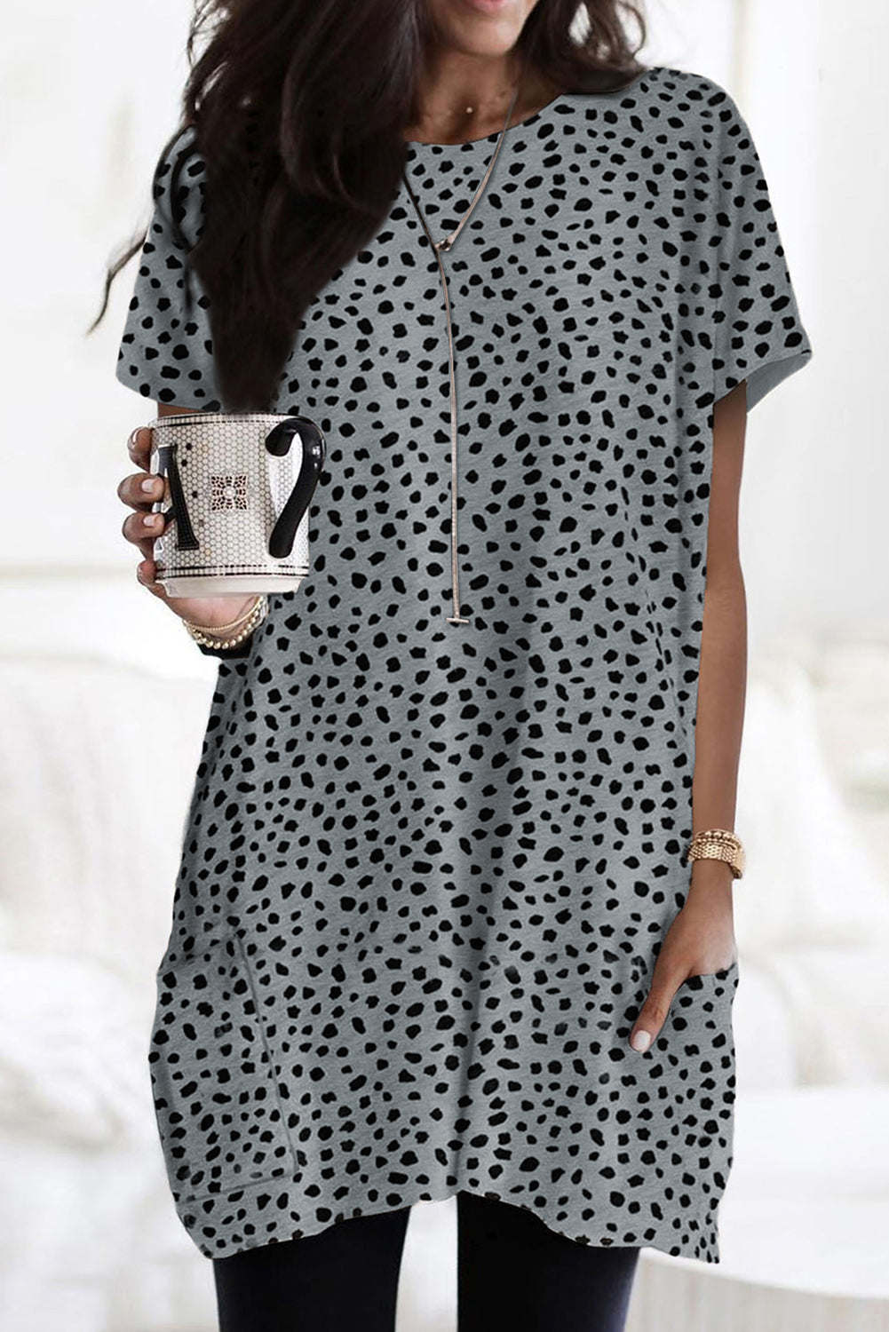 A woman wearing a black leopard print side pockets tunic top.